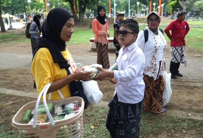 
 Aksi berbagi sayur dengan mengenakan baju adat, sebagai rangkaian Malang Movement: Inclusive Culture, Youth Empowerment, and Green Action Festival di Alun-Alun Kota Malang,  Sabtu (31/10/2026). (Nedi Putra AW).
